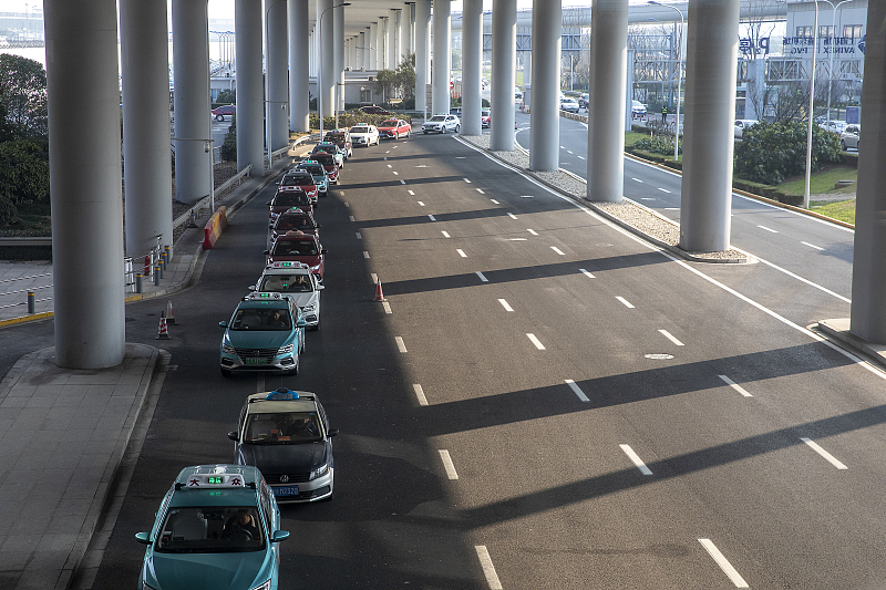 What does the ban and un-ban of online car-hailing services at Pudong Airport signify?